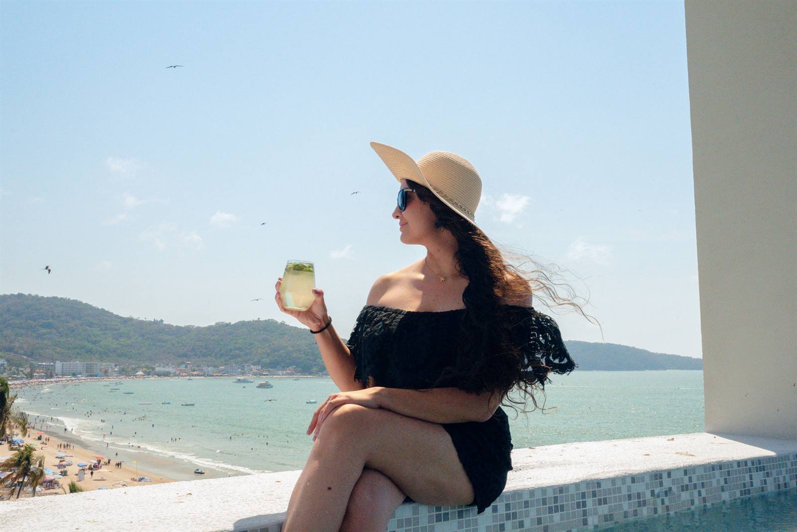 Avenir Armonia Suites: a guest by the pool overlooking the beach and the bay